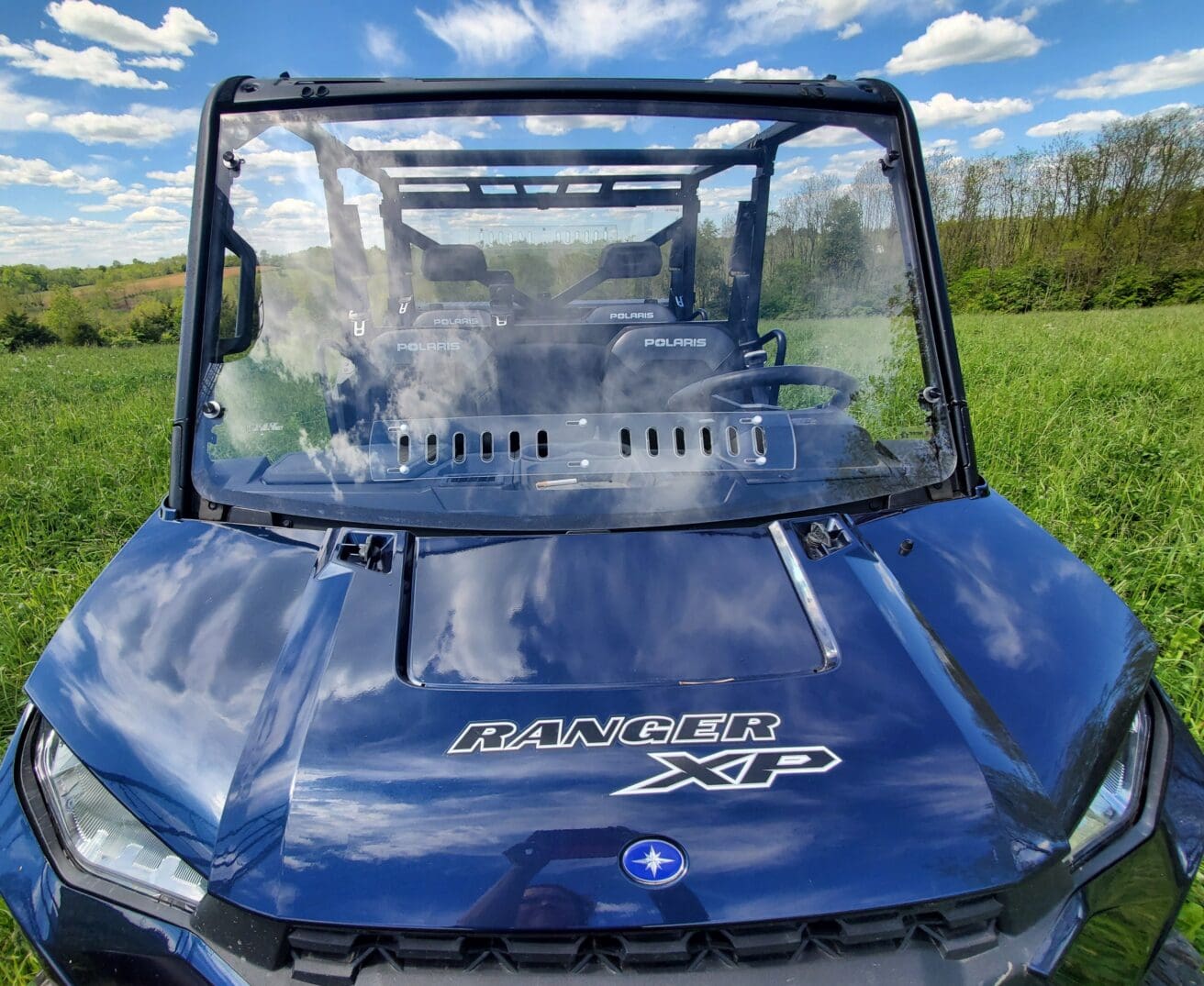 A blue utility vehicle parked in the grass.
