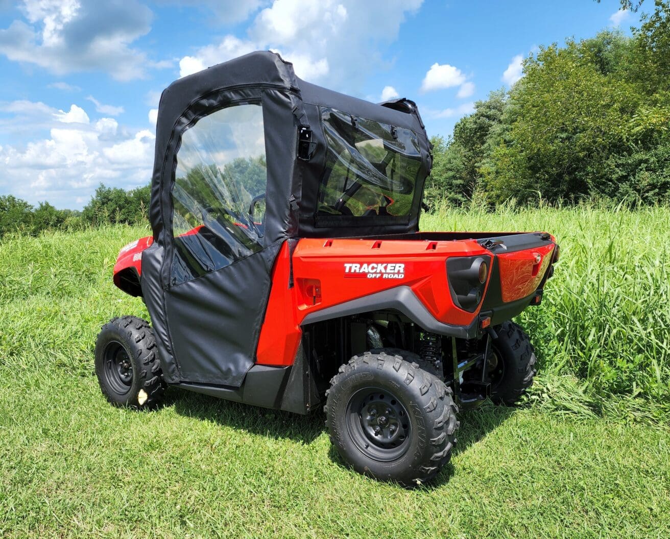 A red utility vehicle parked in the grass.