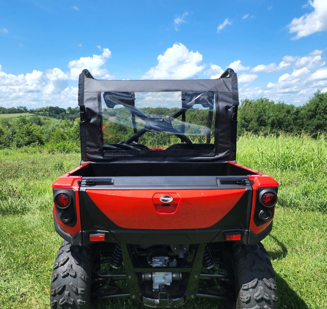 A red utility vehicle parked in the grass.