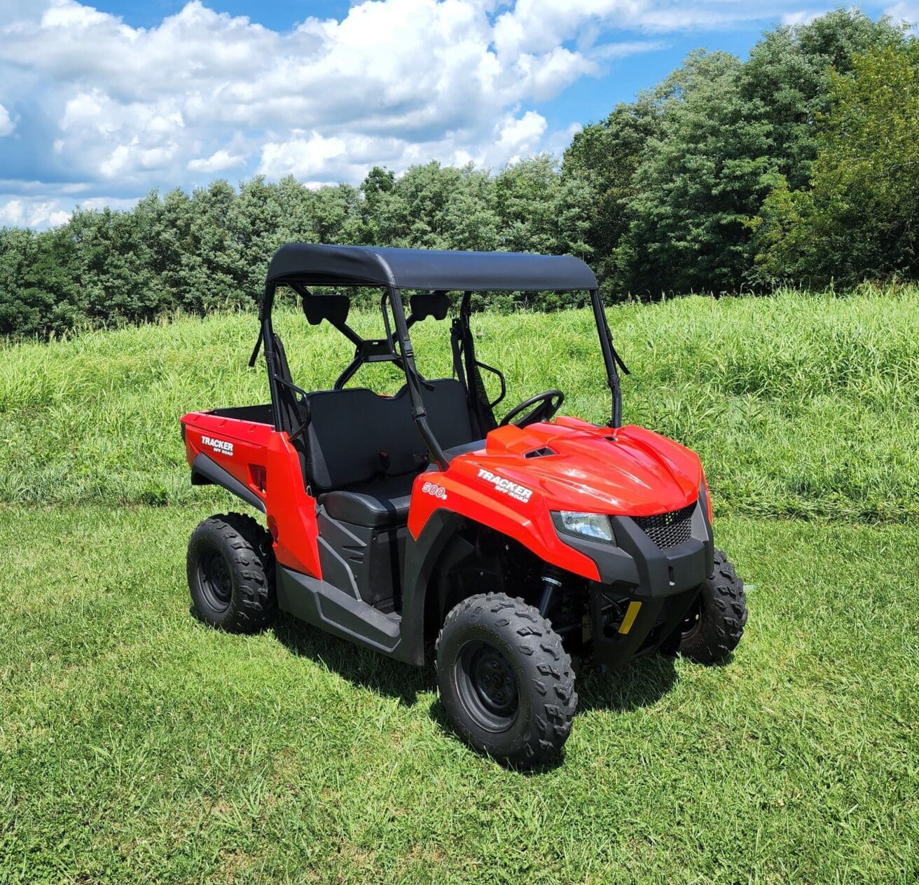 A red utility vehicle parked in the grass.