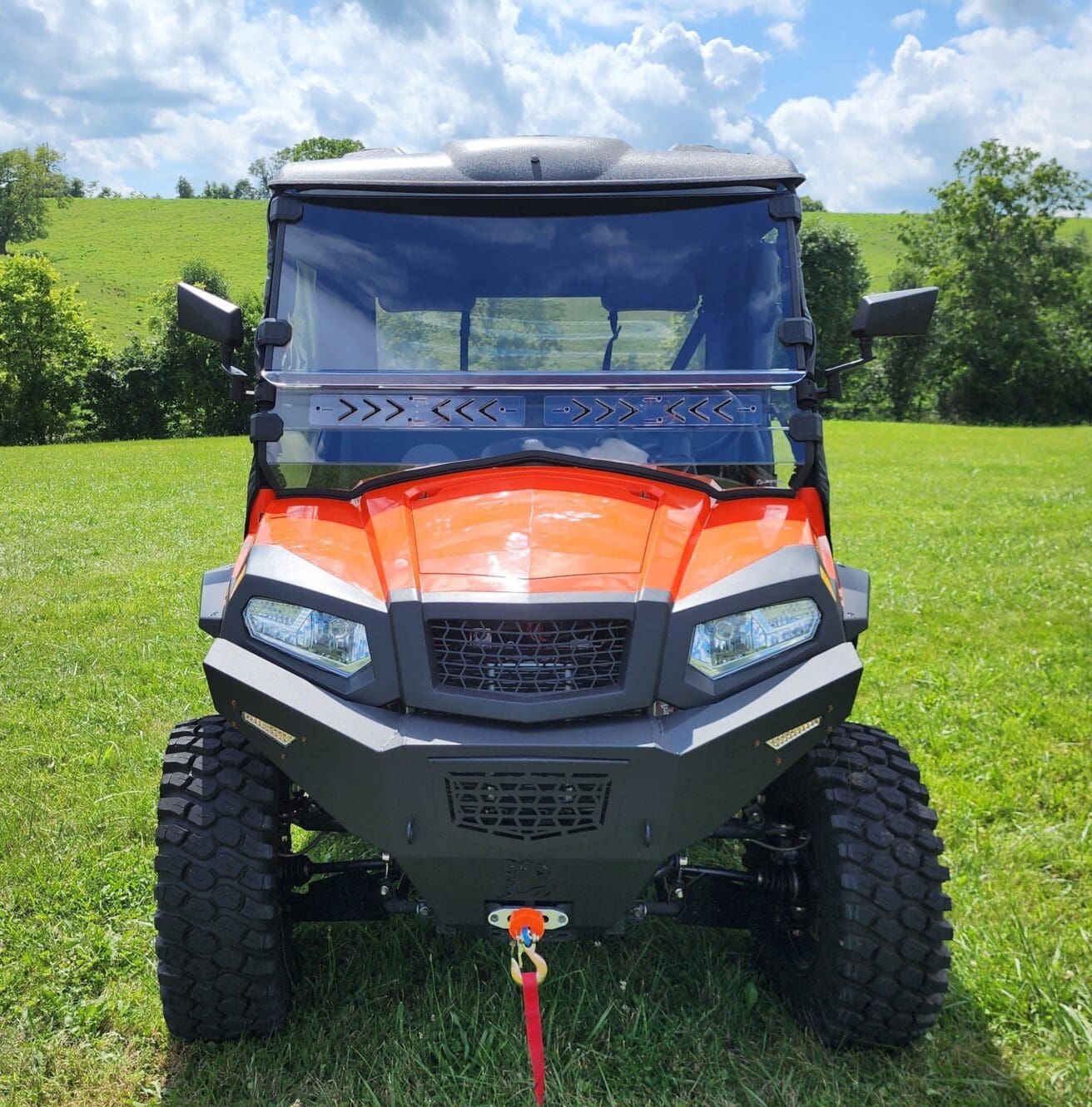 A red utility vehicle parked in the grass.