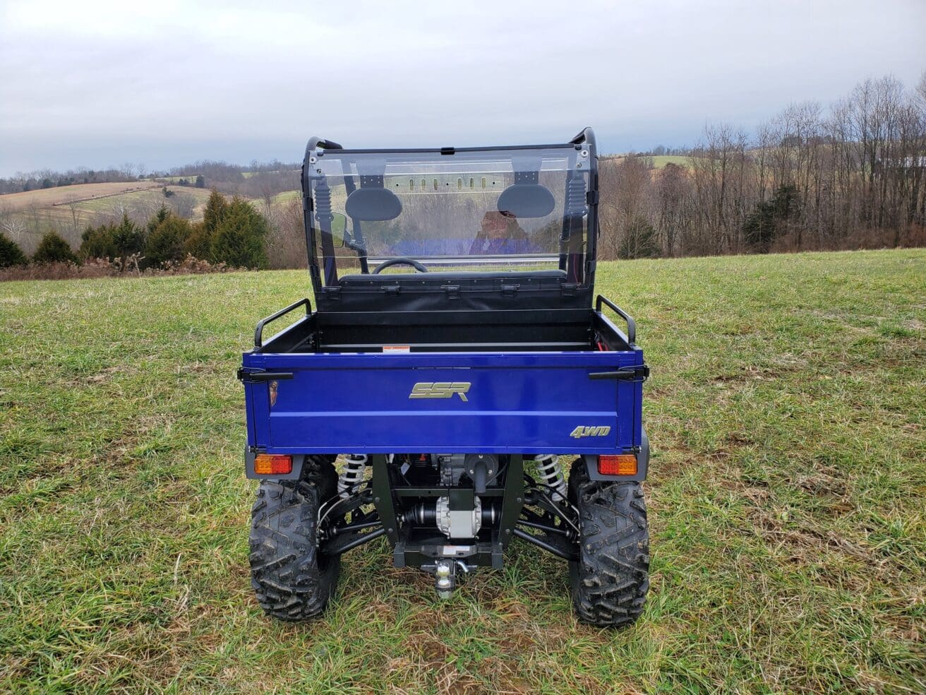 A blue utility vehicle parked in the grass.
