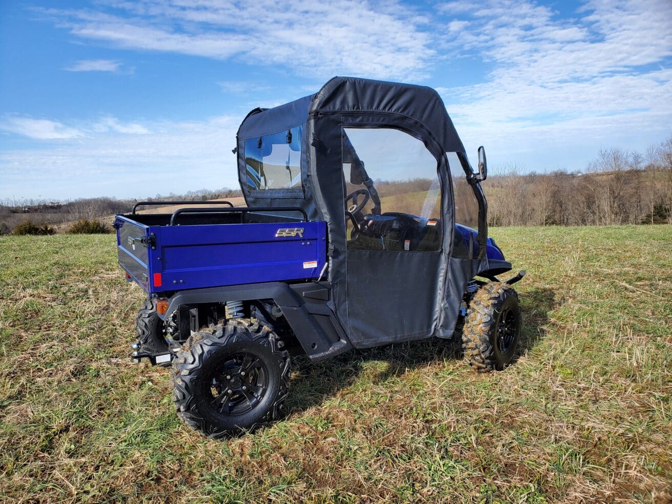 A blue utility vehicle parked in the grass.
