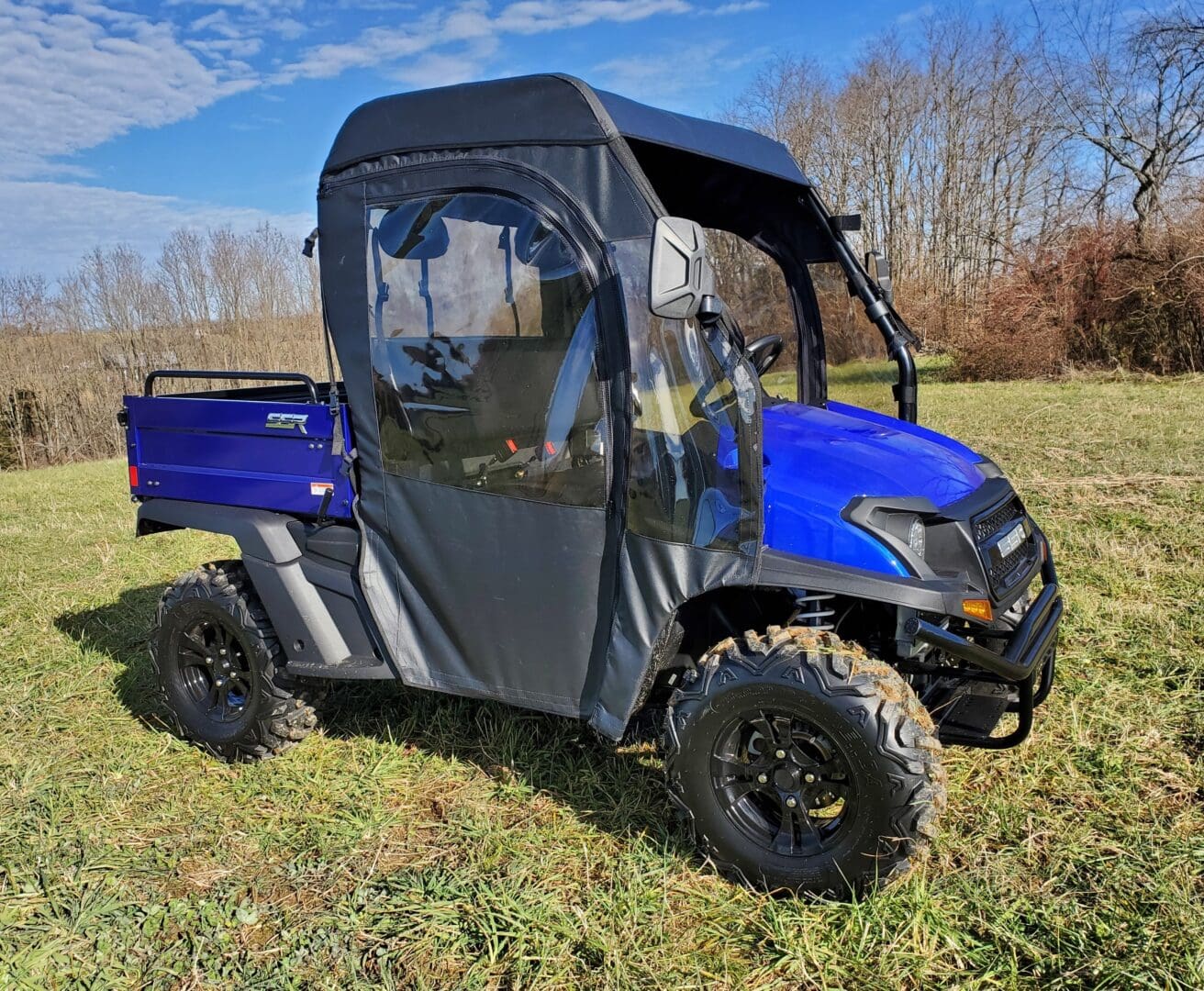 A blue utility vehicle parked in the grass.