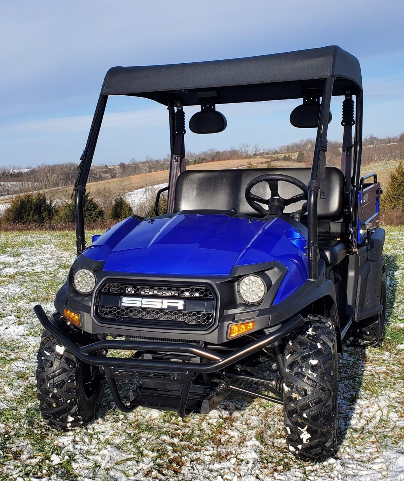 A blue utility vehicle parked in the grass.