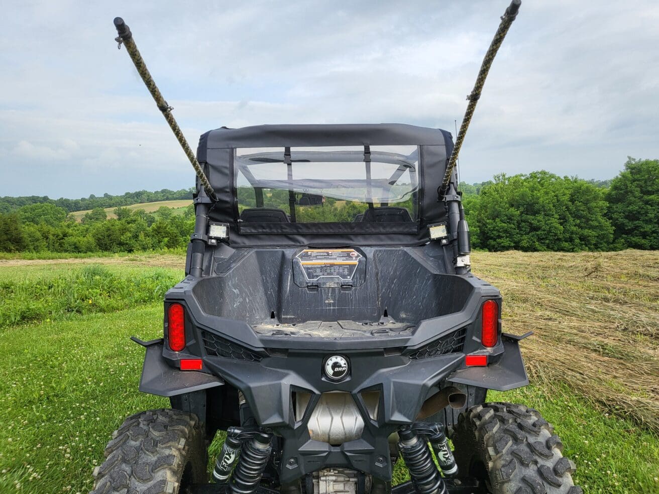 A black atv parked in the grass with two guns on it.