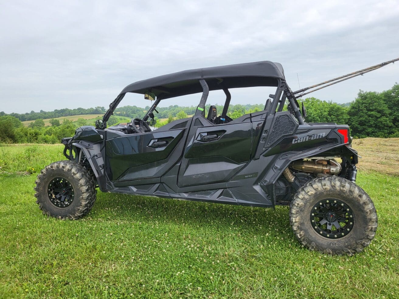 A black four-wheeled vehicle parked in the grass.