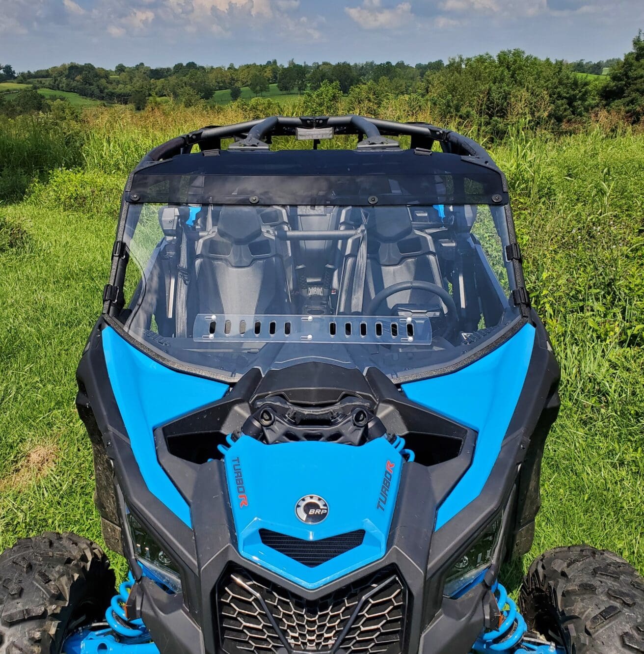 A blue and black atv parked in the grass.