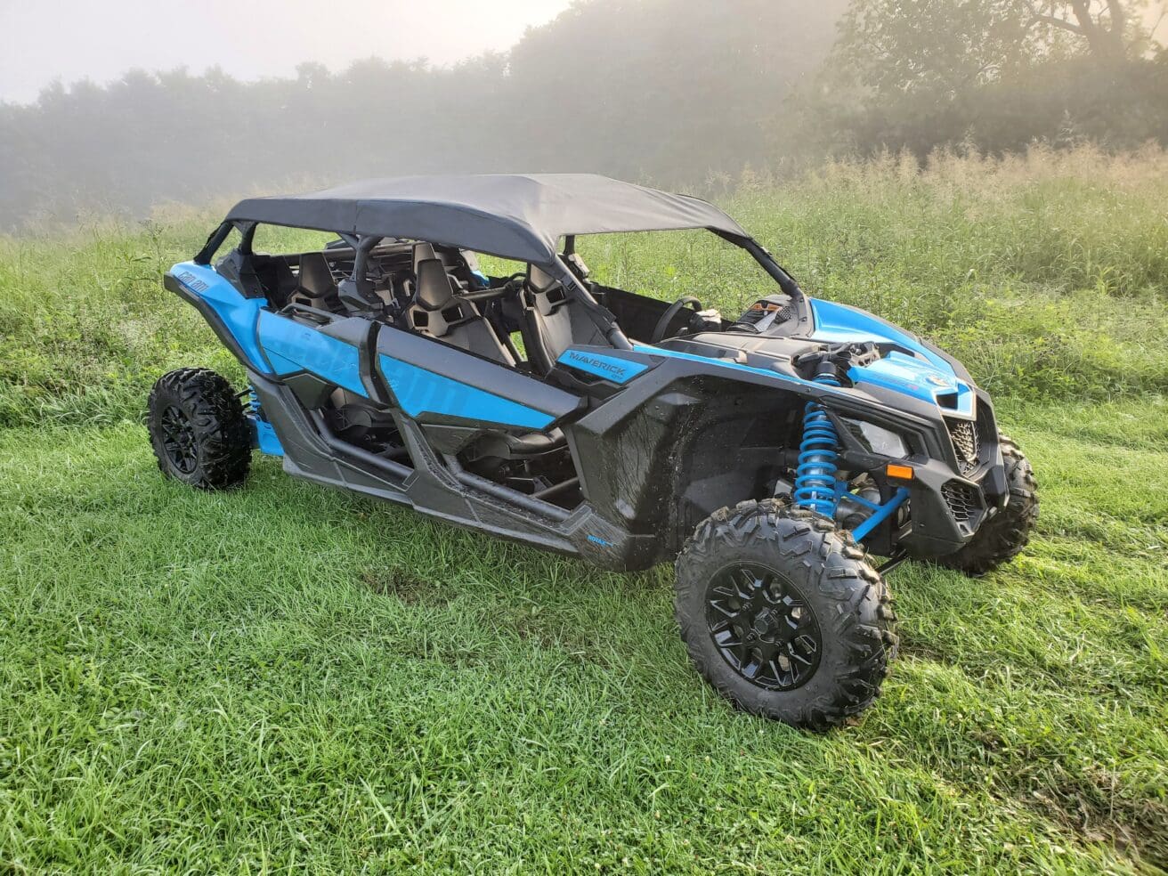 A blue and black four wheeler parked in the grass.