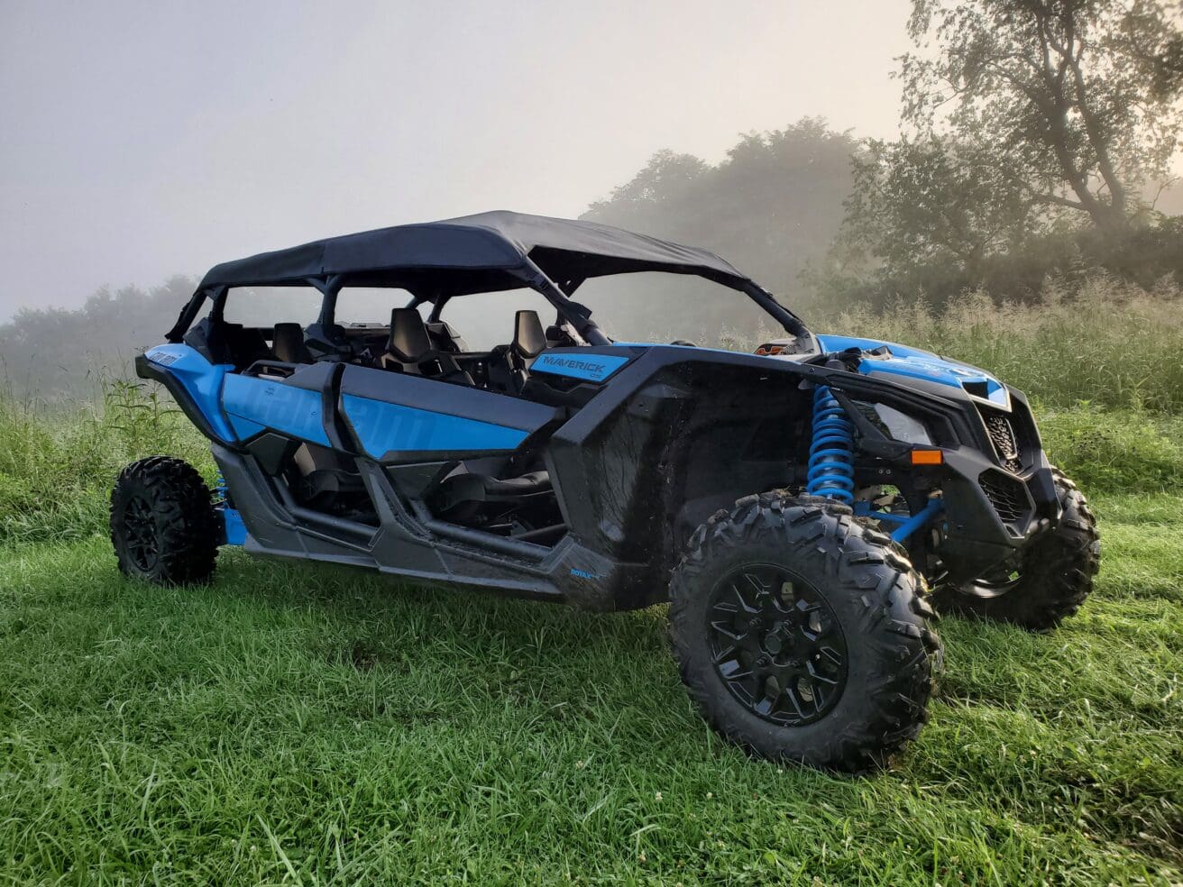 A blue and black four wheeler parked in the grass.