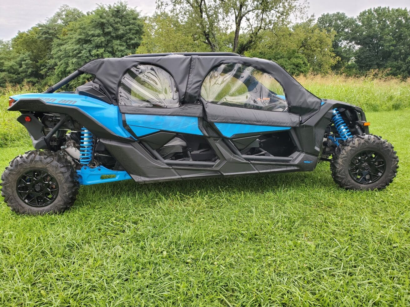 A blue and black four wheeler parked in the grass.