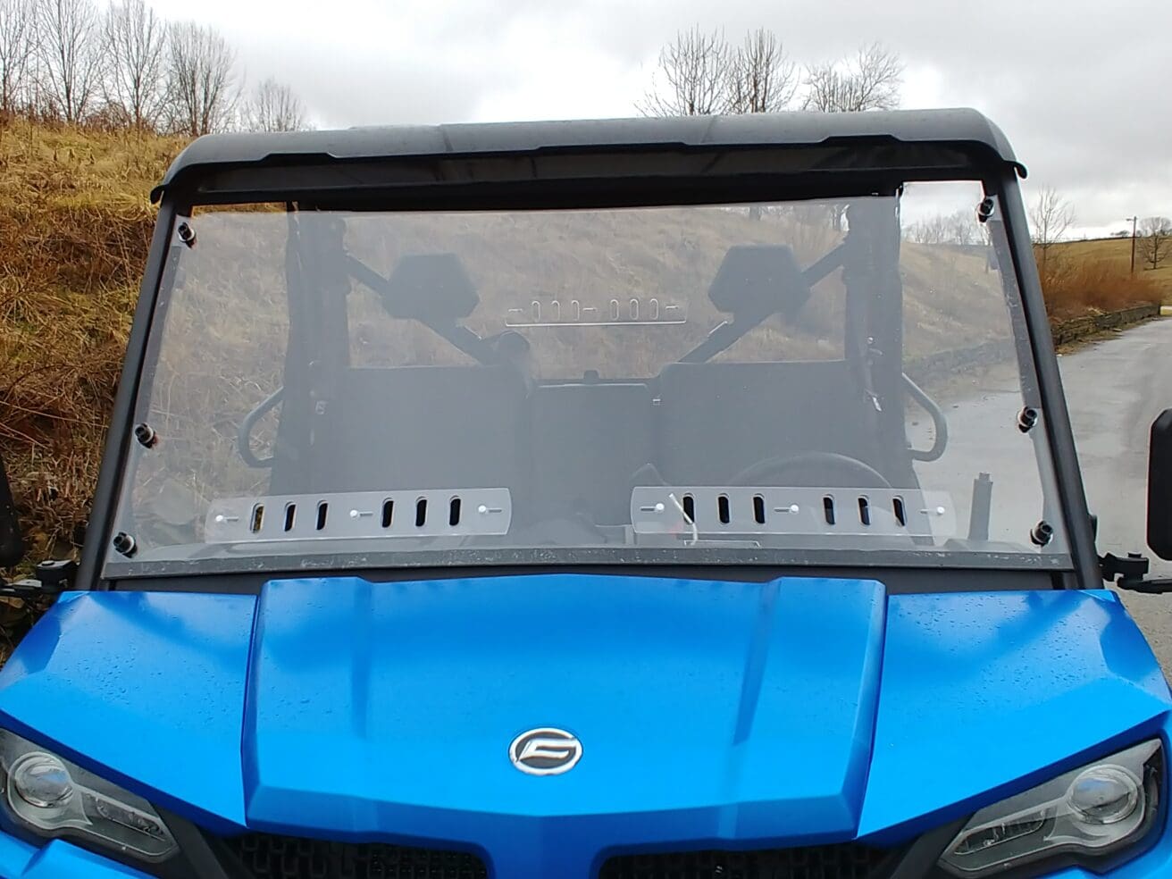 A blue utility vehicle with its windshield up.