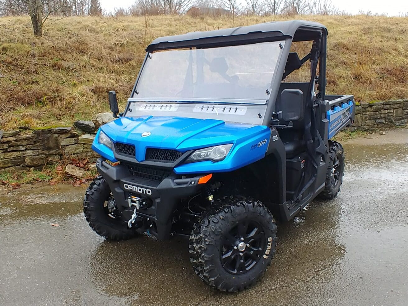 A blue utility vehicle parked in the mud.