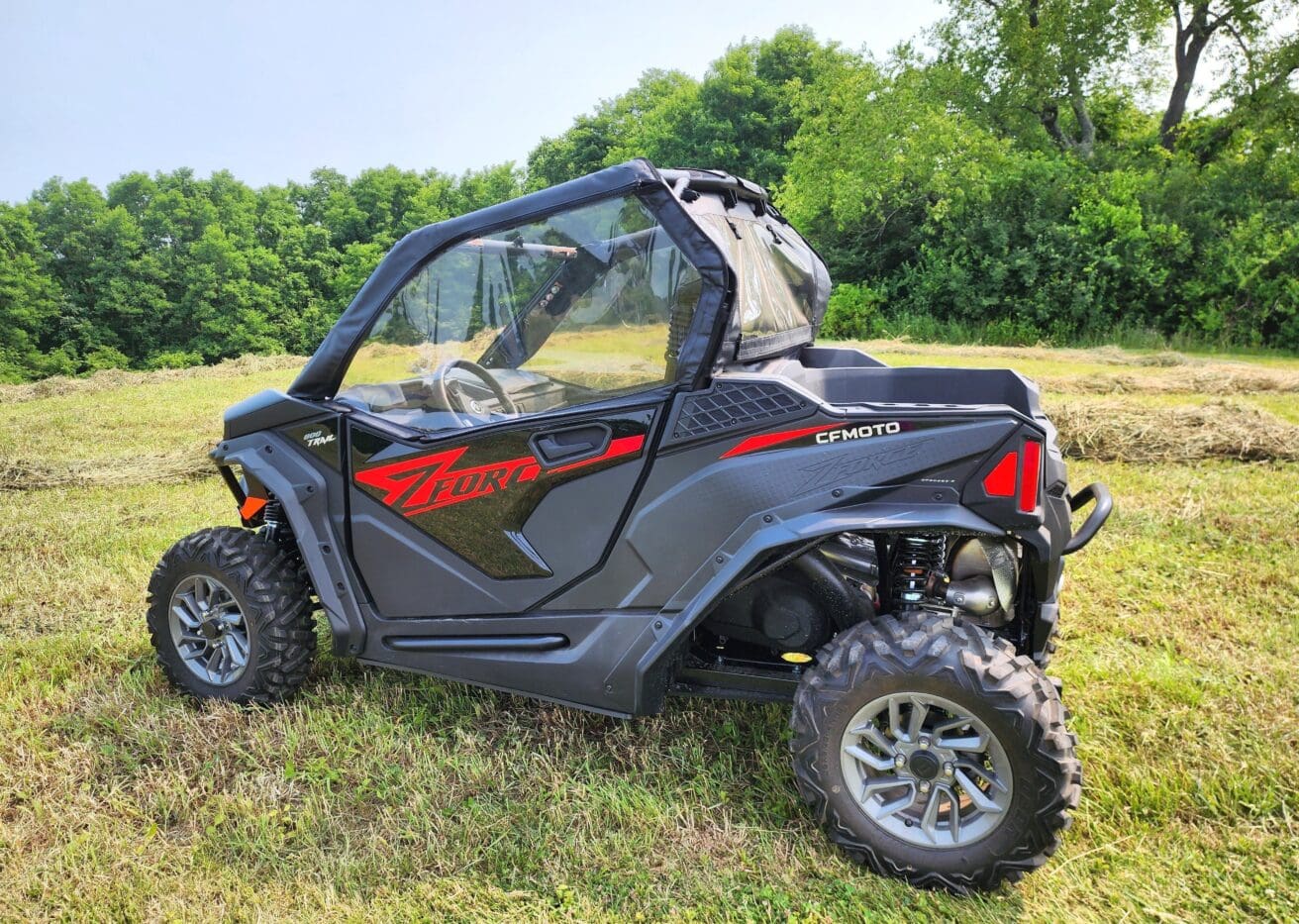 A black and red atv parked in the grass.