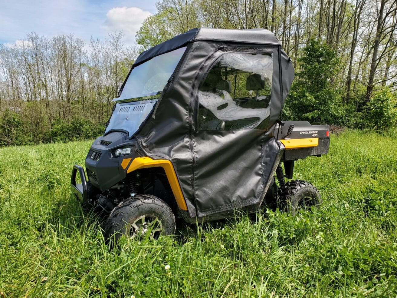 A black and yellow four wheeler parked in the grass.