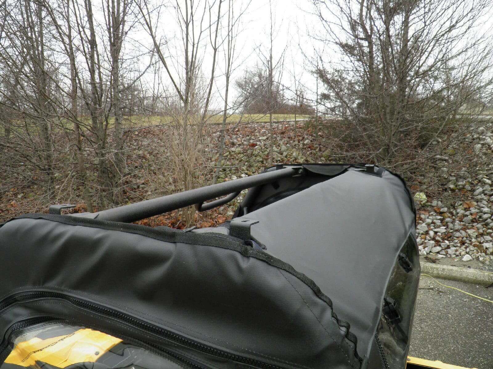 A black tarp covering the top of a vehicle.