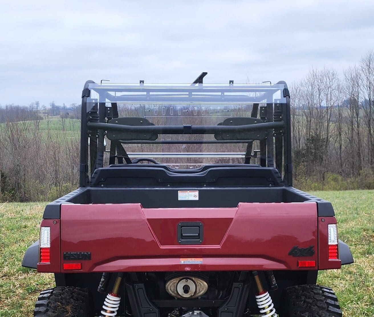 A red truck with a bird sitting on the back of it.