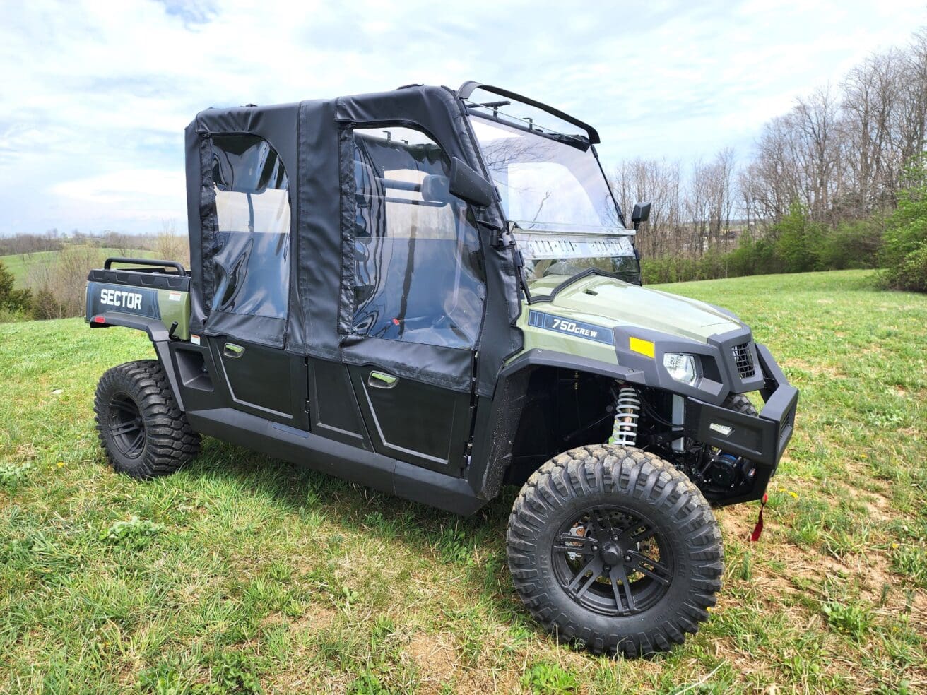 A green utility vehicle parked in the grass.