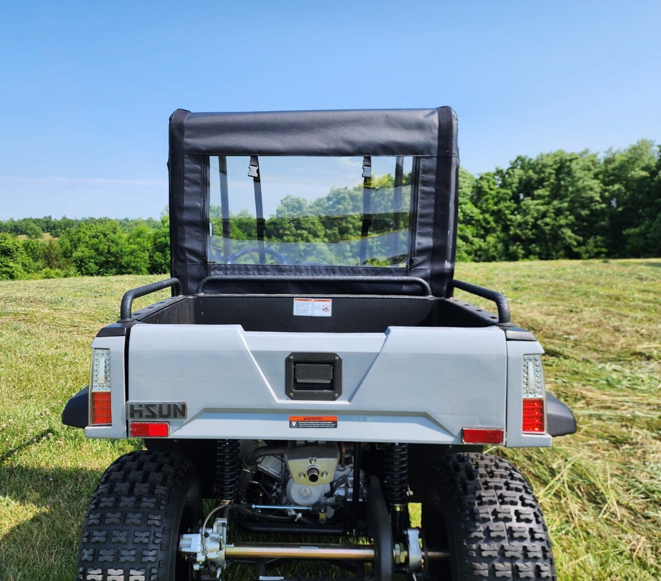 A silver utility vehicle parked in the grass.