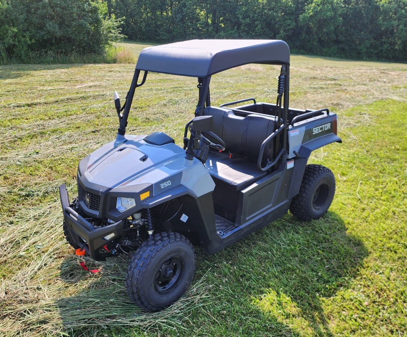 A blue utility vehicle parked in the grass.