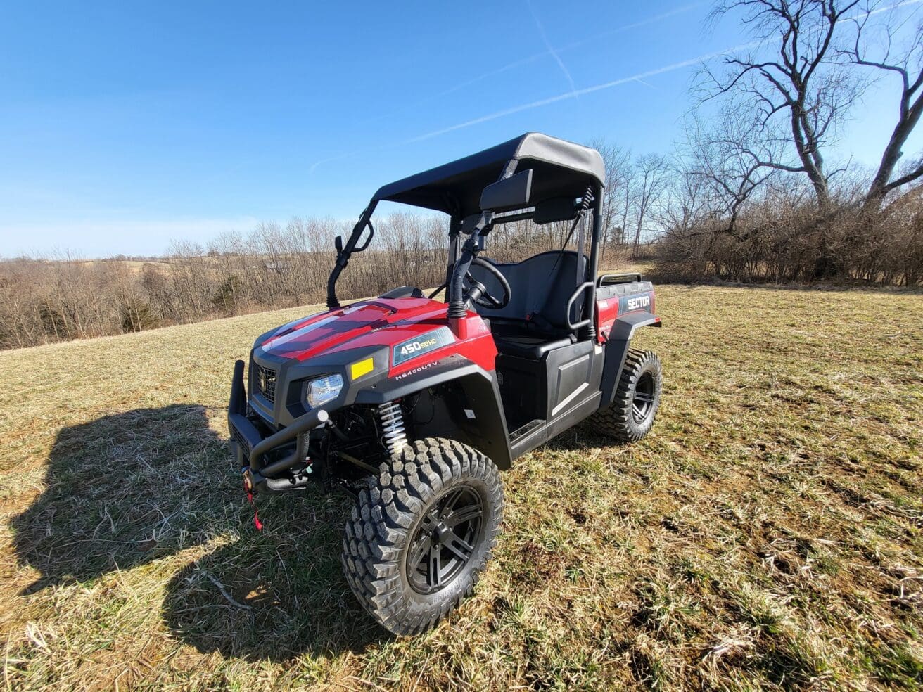 A red utility vehicle parked in the grass.