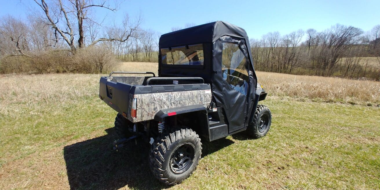 A black and gray utility vehicle parked in the grass.