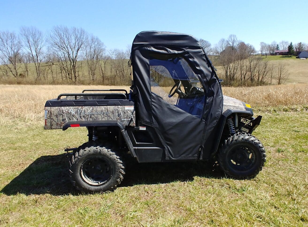 A black and silver utility vehicle parked in the grass.