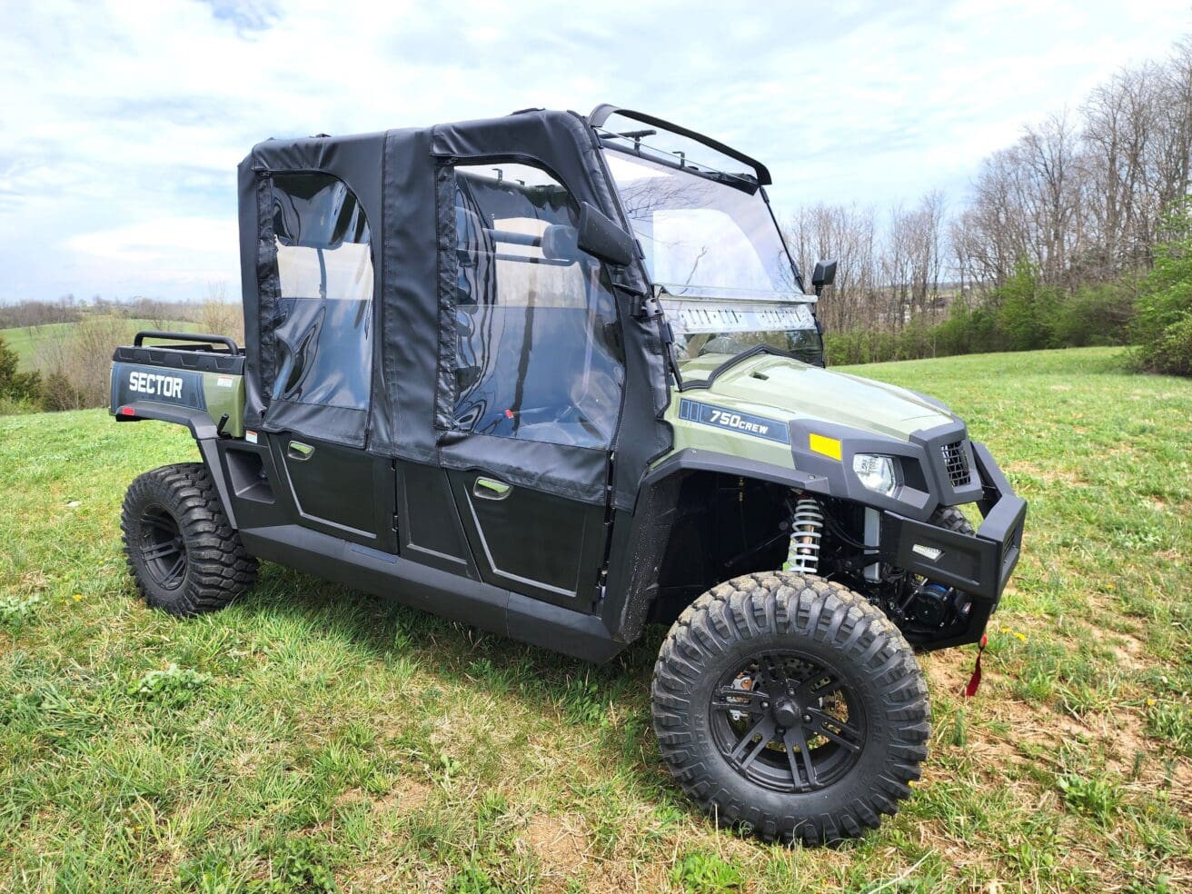 A green utility vehicle parked in the grass.