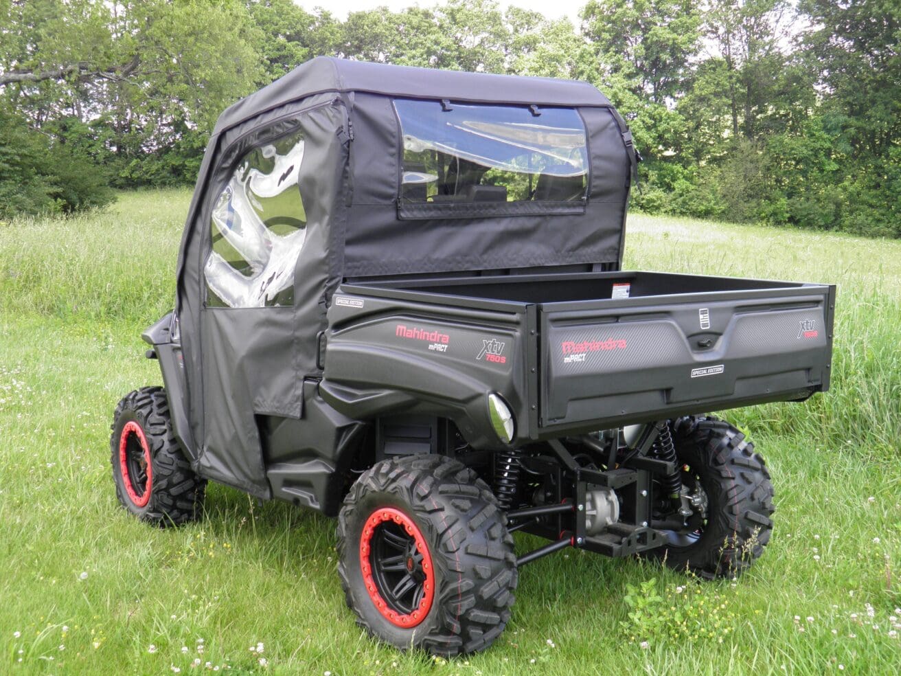 A black utility vehicle with a cover on it's back.