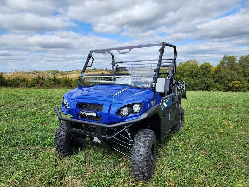 A blue utility vehicle parked in the grass.