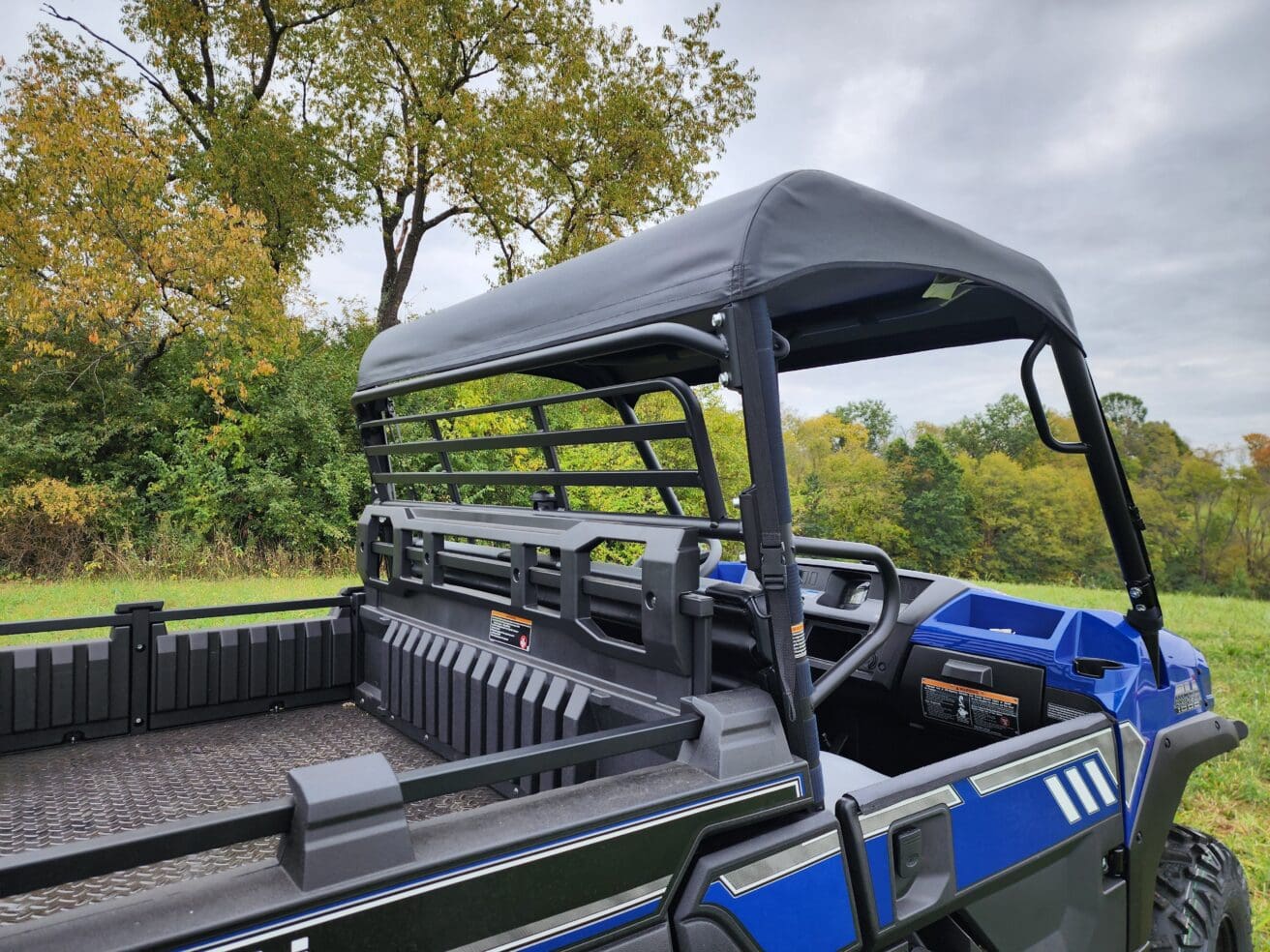A large blue truck with a black cover on it.