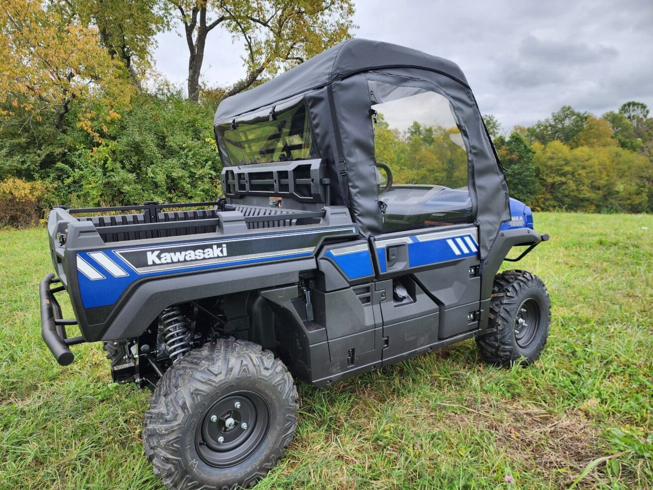 A blue and black utility vehicle parked in the grass.