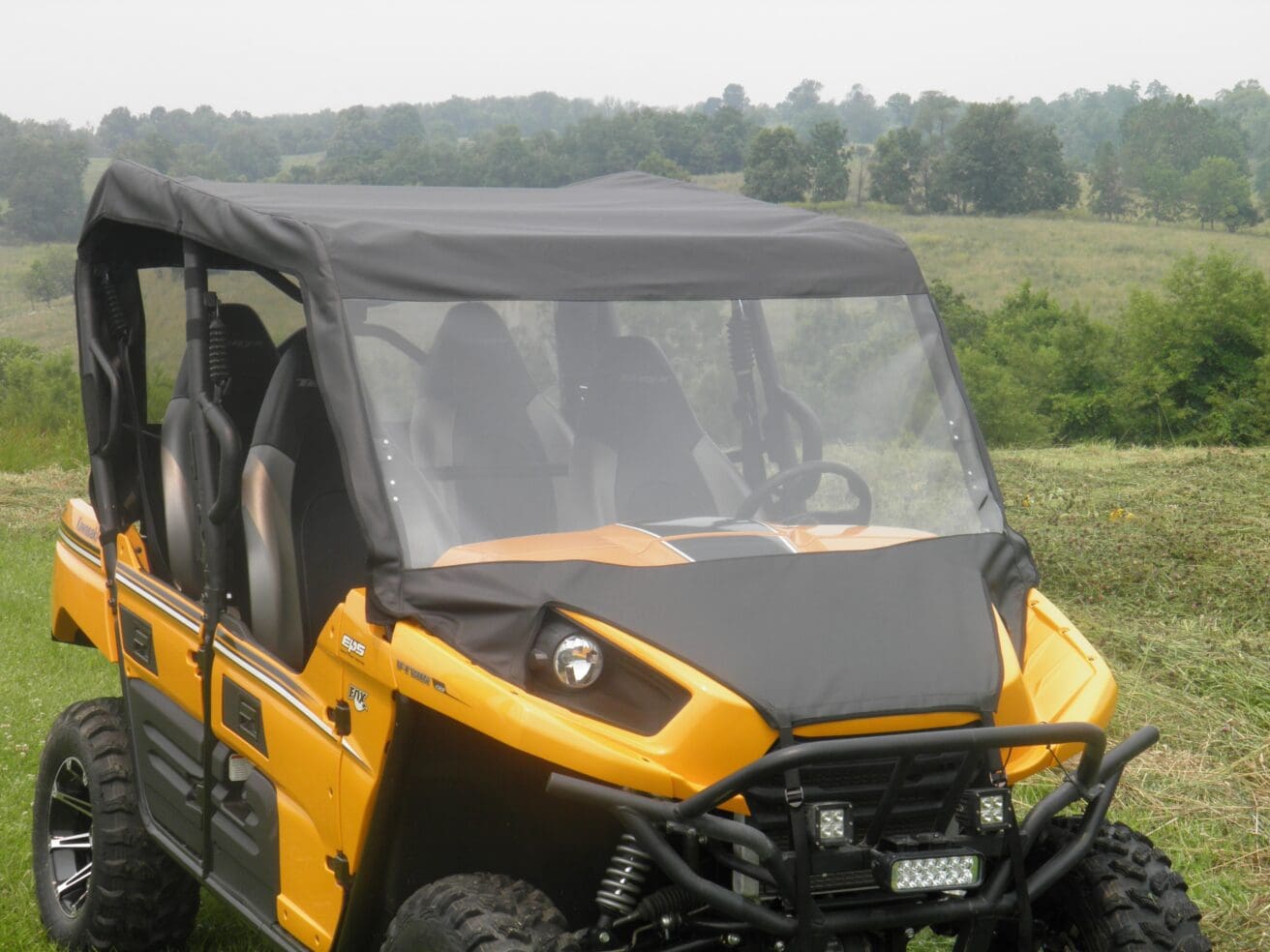 A yellow and black utility vehicle parked in the grass.