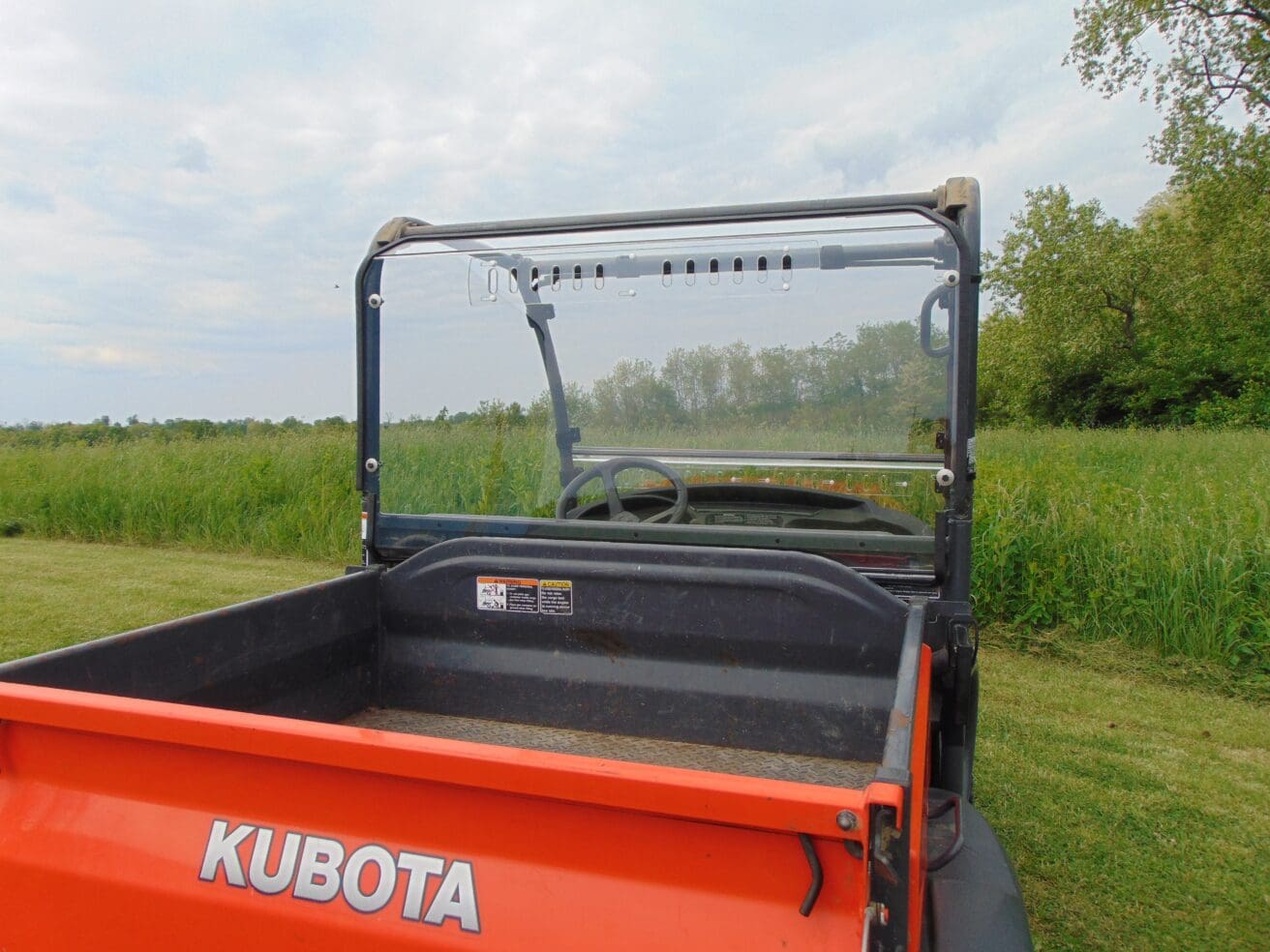 A close up of the back end of an orange utility vehicle.