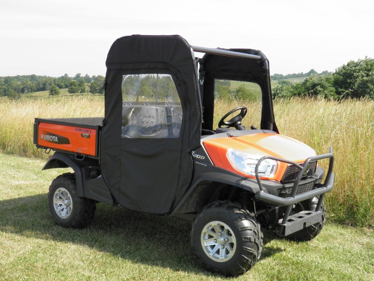 A small orange and black utility vehicle parked in the grass.