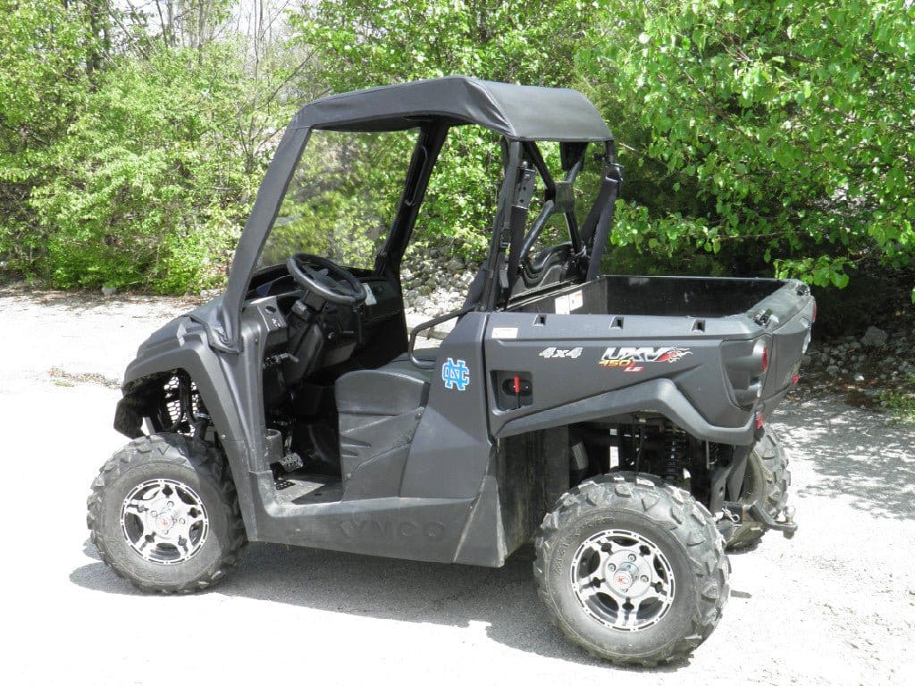 A black utility vehicle parked in the middle of a driveway.