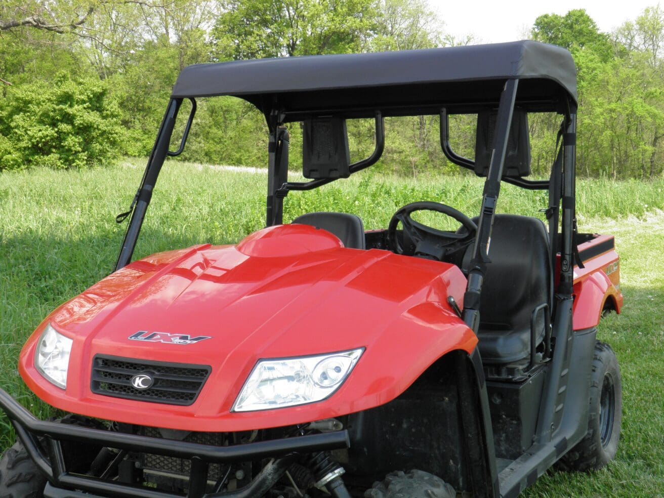 A red utility vehicle parked in the grass.