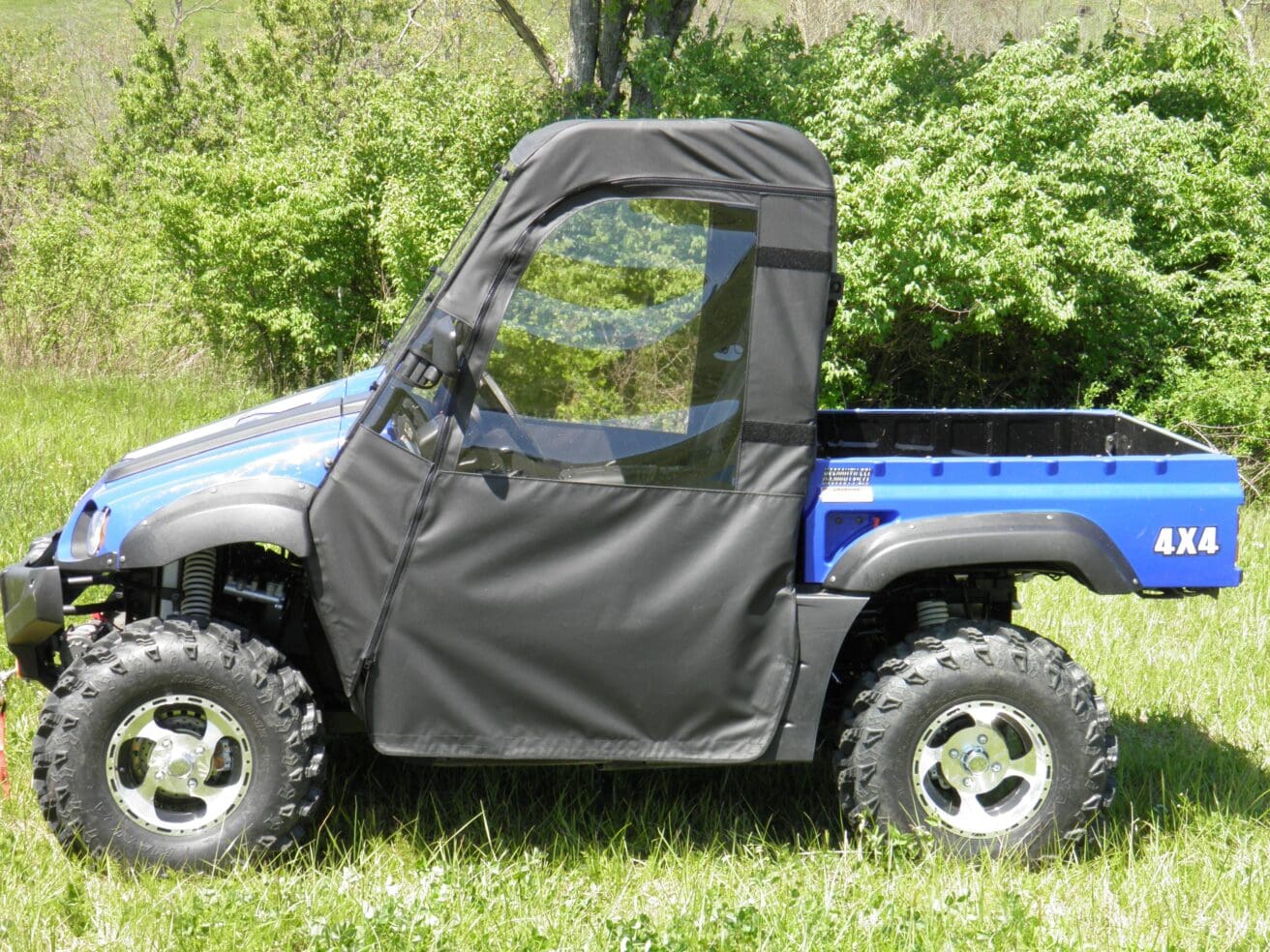 A blue utility vehicle parked in the grass.