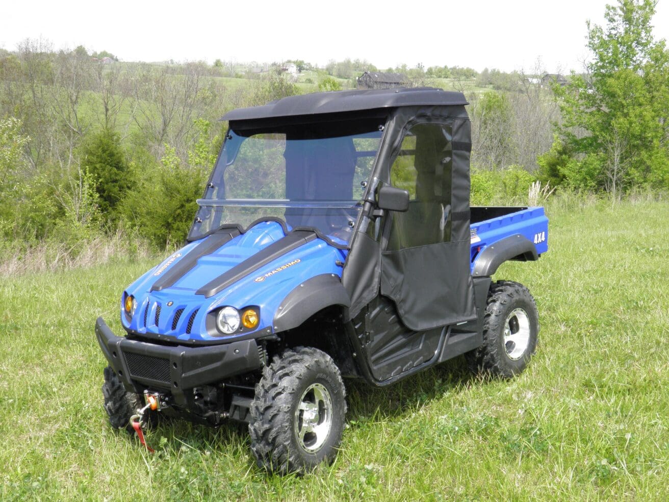 A blue utility vehicle parked in the grass.