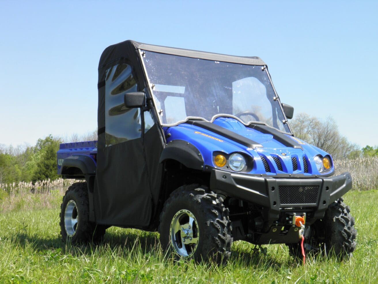 A blue utility vehicle parked in the grass.