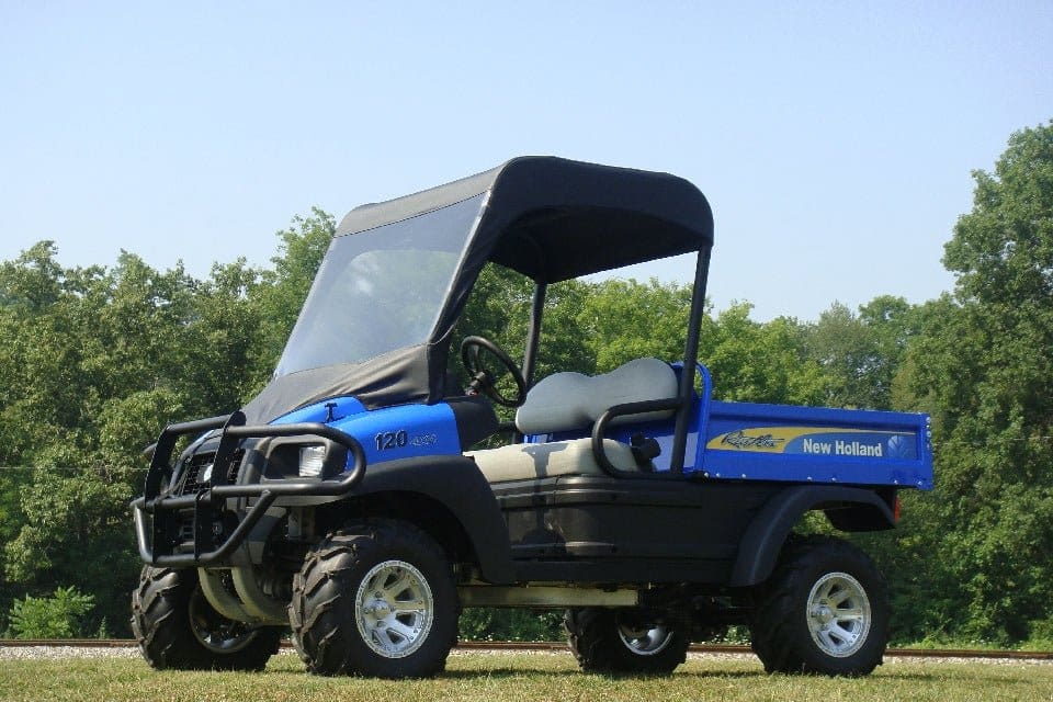 A blue utility vehicle parked in the grass.