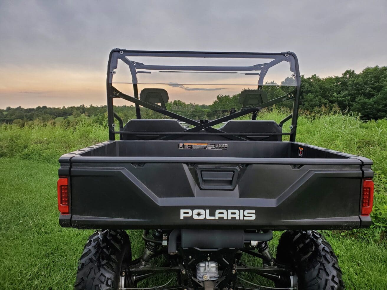 A black polaris ranger parked in the grass.