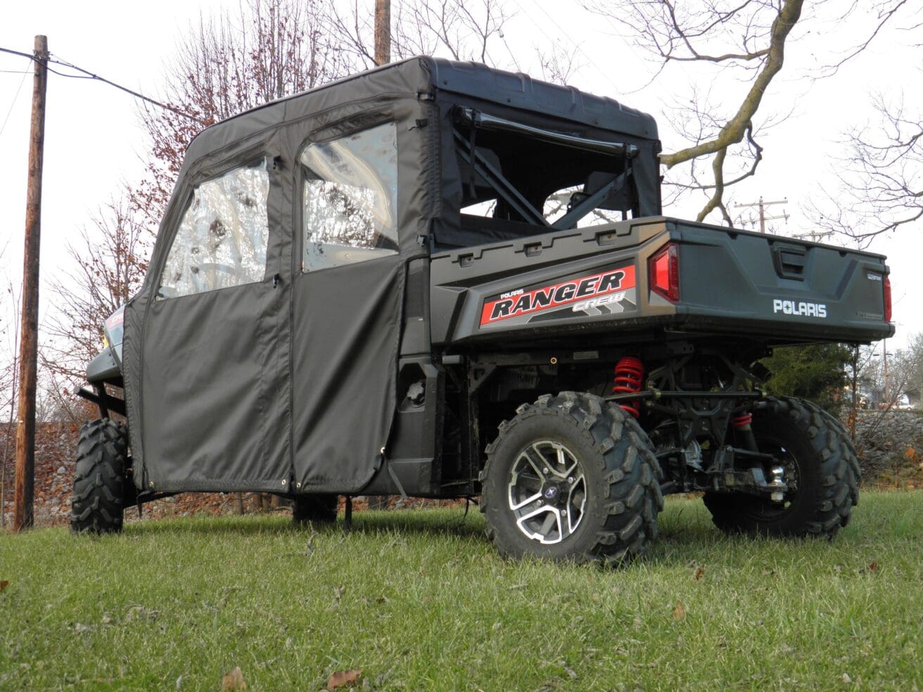 A black utility vehicle with a tarp over the back.