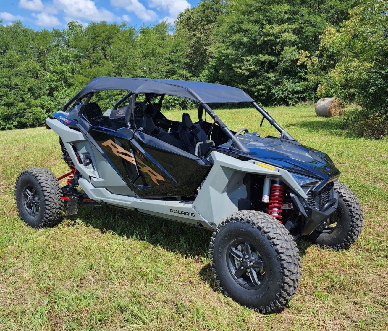 A blue and white four-wheeled vehicle parked in the grass.