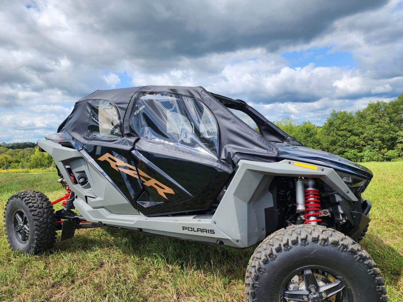 A black and silver vehicle parked in the grass.