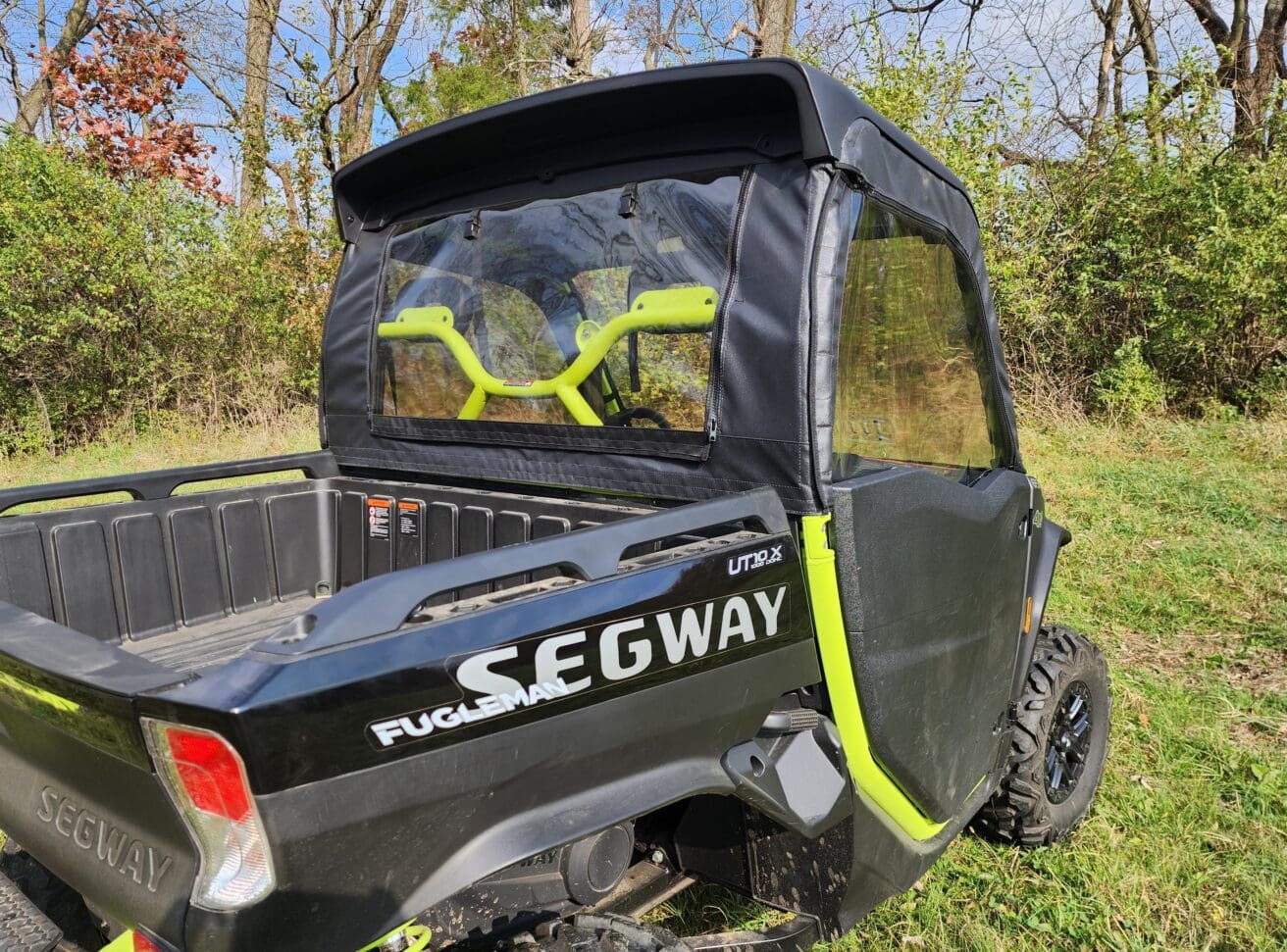 A black and yellow utility vehicle parked in the grass.