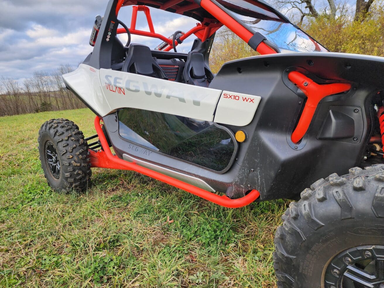 A red and white buggy parked in the grass.