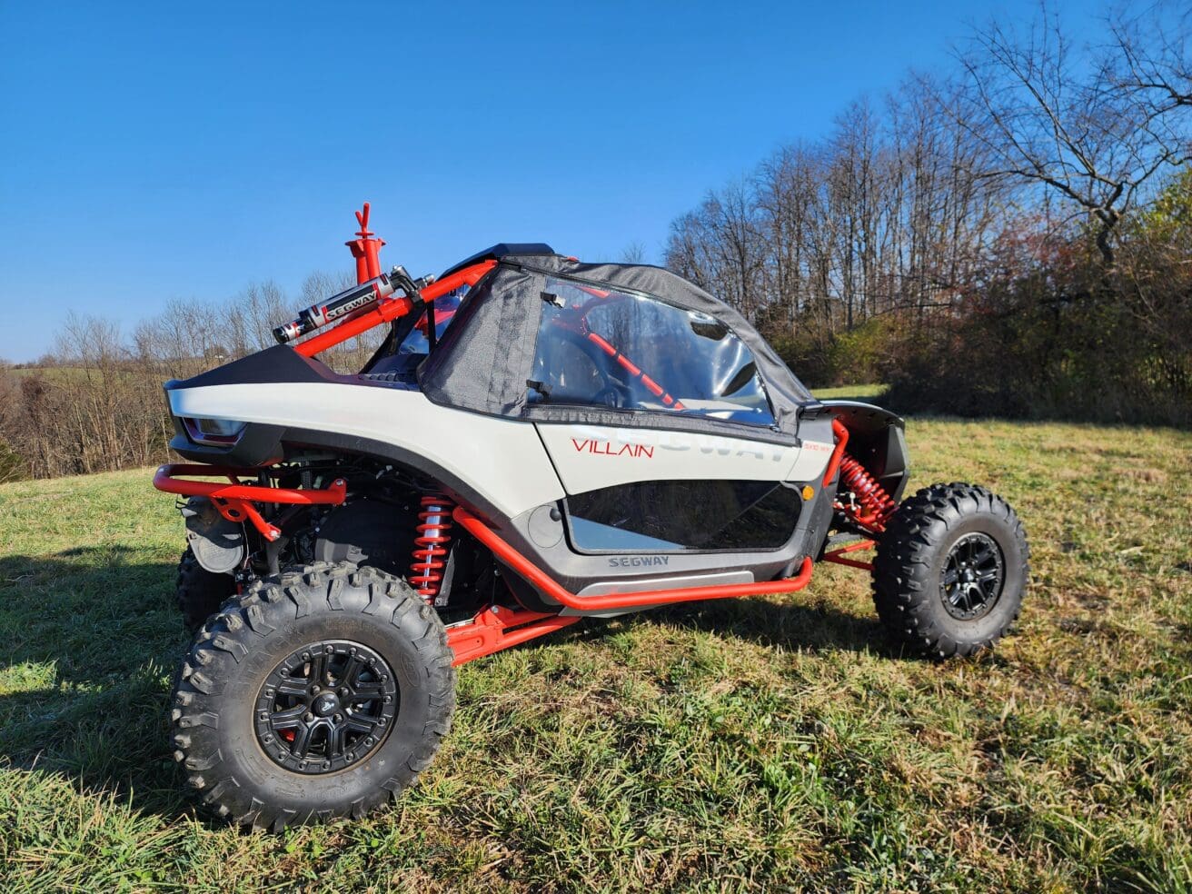 A white and red buggy parked in the grass.