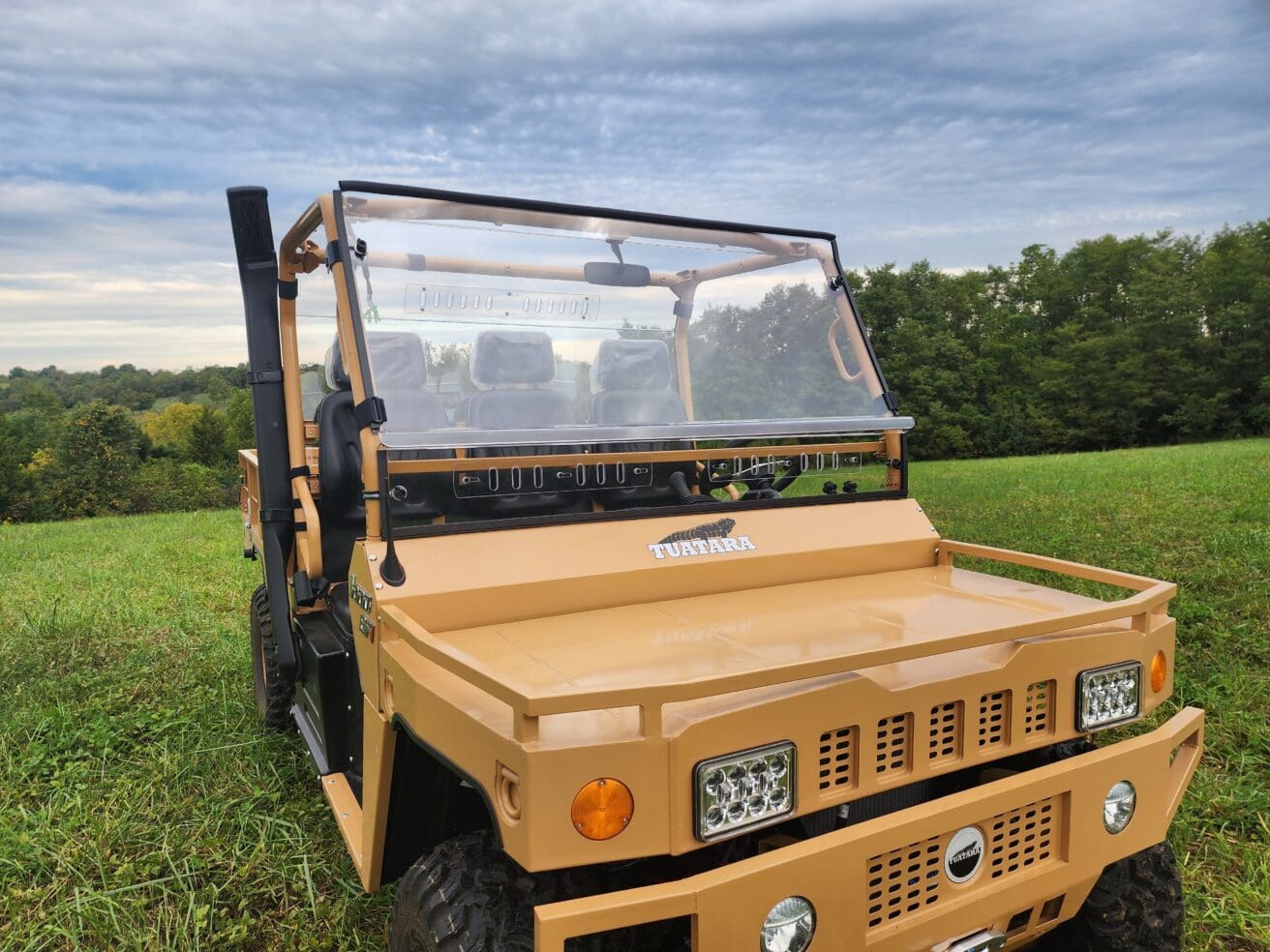 A yellow utility vehicle parked in the grass.