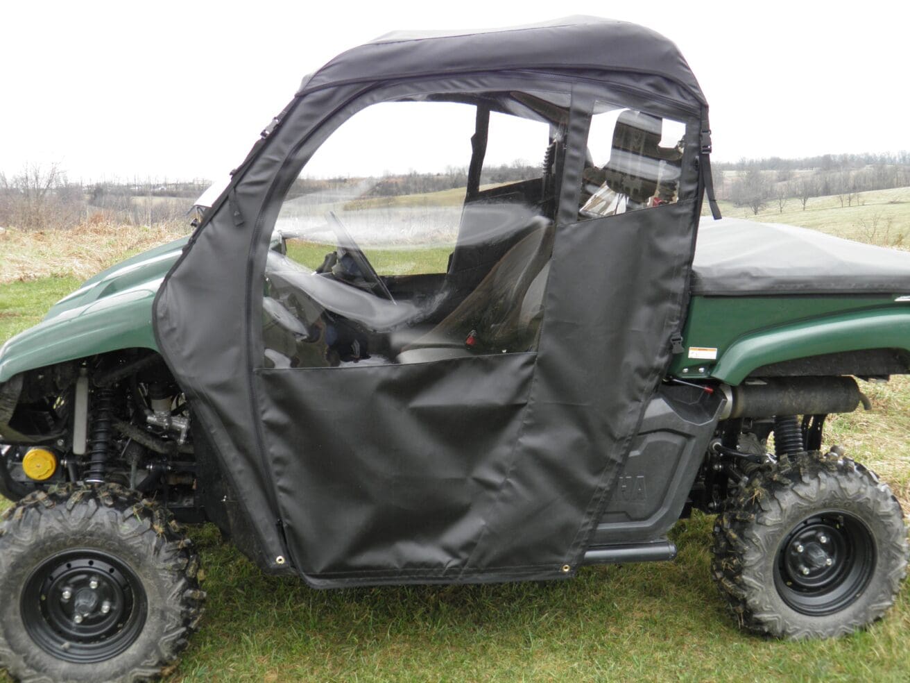 A green utility vehicle with its doors open.